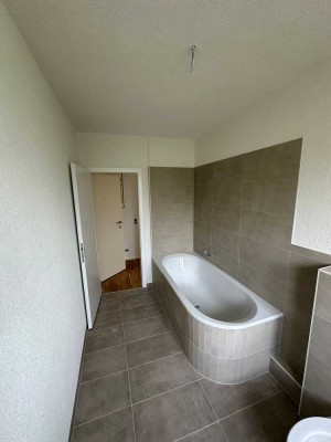 Erstbezug nach Sanierung mit Balkon und Einbauküche: Geschmackvolle 3-Zimmer-DG-Wohnung