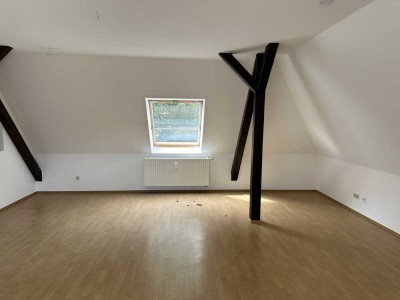 Dachgeschosswohnung mit großem Wohnzimmer und sichtbaren Holzbalken