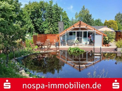 Kleines Haus auf einem angelegten Grundstück mit Badeteich und Nebengebäuden
