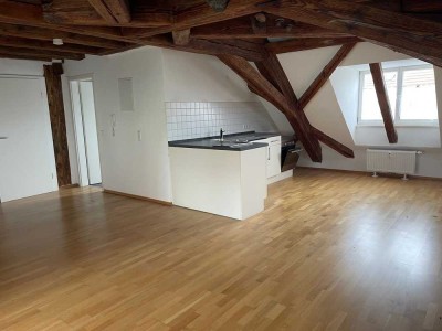 Modern-rustikales Ambiente durch sichtbares Gebälk in einer sehr großen 1-Zi-DG-Whg. mit Loggia