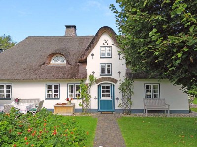reetgedecktes Friesenhaus in historischer Umgebung