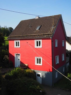 Modernisiertes Fachwerkhaus mit Scheune und ausgebautem Holzhaus auf naturnahem Grundstück.
