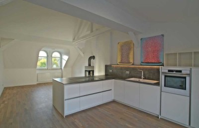 Großzügige, stilvoll ausgebaute Dachgeschosswohnung mit hochwertiger Küche, Kaminofen und Balkon zu