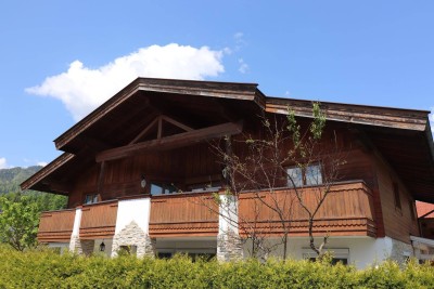 Ein großes Haus mit zwei Wohneinheiten in einer ruhigen Straße, umgeben von wunderschöner Natur