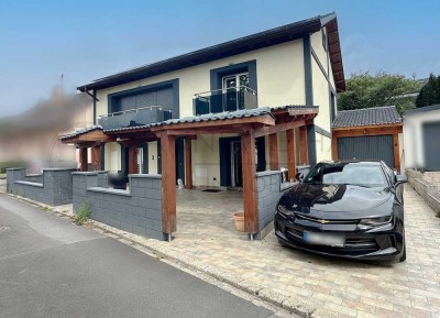 Stilvolles Einfamilienhaus mit Garten, Garage und großer Terrasse.